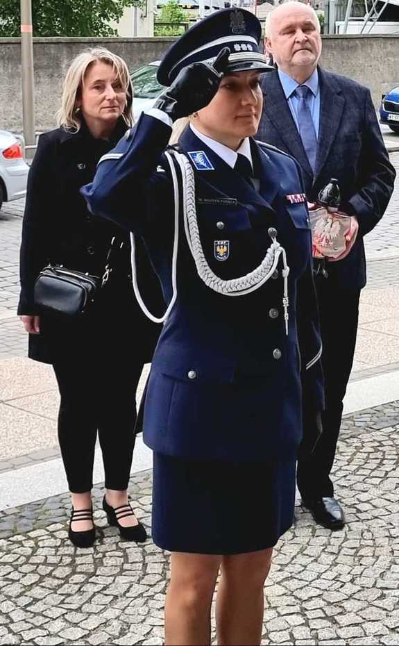 Komendant Wojewódzki Policji w Opolu podczas składania honoru pod tablicą upamiętniającą patrona komendy